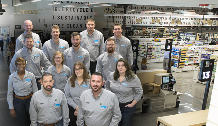 GreenWise Store Managers group photo placed on top of a GreenWise store lobby picture