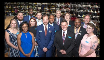 Mt. Brook GreenWise Market managers group photo in front of the wine bottles