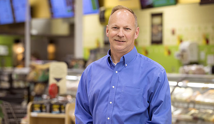 Publix Associate, Allen Brown standing in a store in a blue dress shirt.