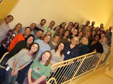 Pharmacy operations associates stand on a staircase for a photo