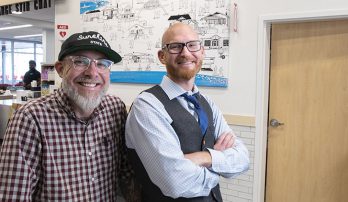 Artists Bump and Fred stand in front of their in-store mural.