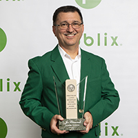 oe Blaszczak ATL Division store manager, holds his award dressed in his best green blazer