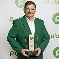 Dank Murphy LAK Division store manager, holds his award dressed in his best green blazer