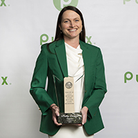 Kathy Leonard, Pharmacy Operations Manager, holds her award dressed in his best green blazer